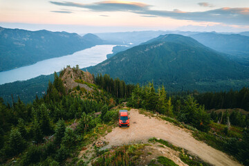 Aerial shot of shot of a pickup truck standing on the cliff with a backdrop of North Cascades Mountains and Lake Kachess in Snoqualmie Pass, Washington State.   © Victoria Nefedova