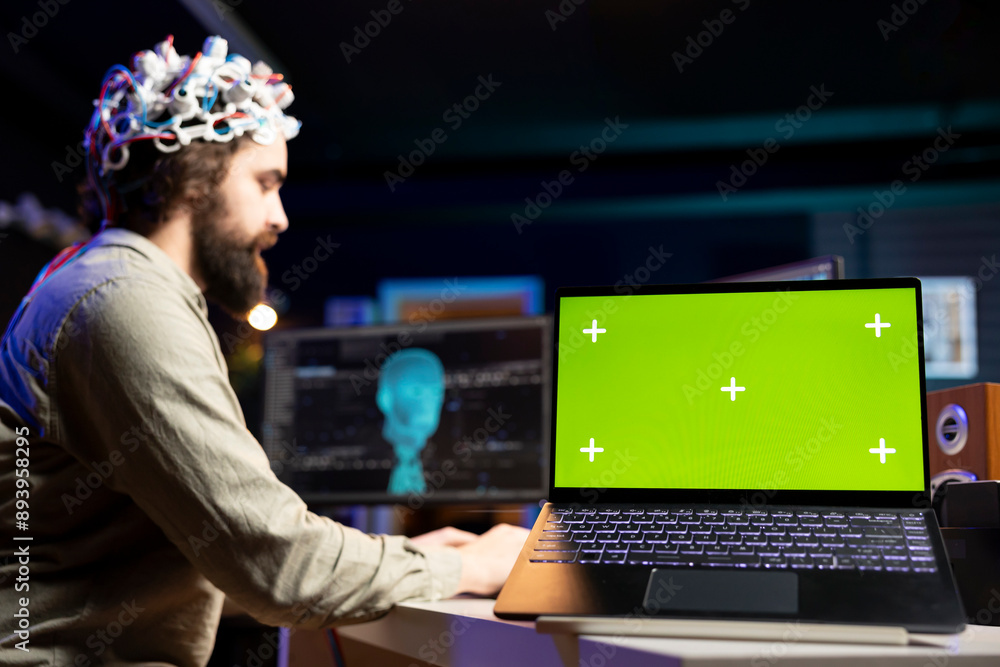 Poster focus on green screen laptop used by programmer using eeg headset to upload mind into pc. close up o