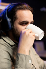Computer engineer listening music and drinking coffee while updating artificial intelligence neural...