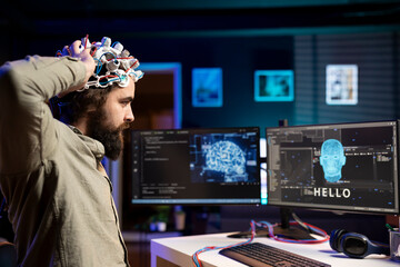 Man placing EEG headset on head to communicate with artificial intelligence entity with...