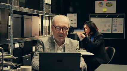 Senior law agent examining financial records to find account information and find criminal, working...