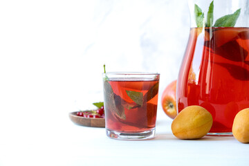 Fruit drink. Jug with a drink made from berries, apricots and apples. Refreshing summer berry drink.