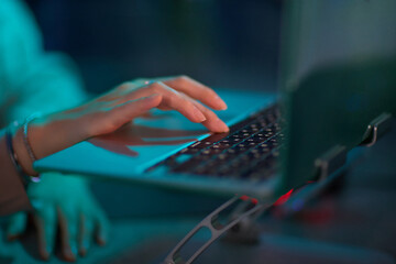Closeup of an office worker typing on a laptop in a professional workplace setting