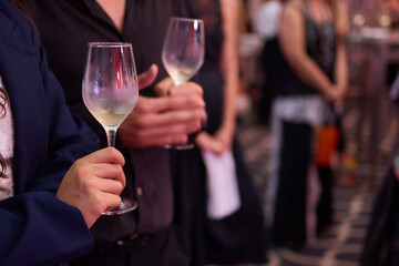 At a lively nightclub, people are enjoying wine and socializing in a chic ambiance