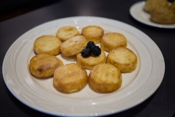 Fried potato rounds with caviar on a white plate can elevate your appetizer selection
