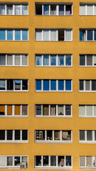 yellow painted residential highrise with multiple floors and window exterior visible.