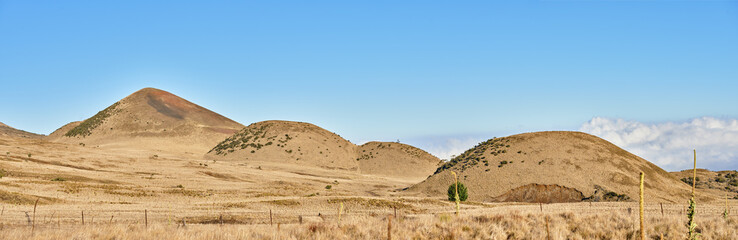 Desert, volcano and blue sky in nature environment with eco friendly, travel and tourism location. Landscape, banner and outdoor wilderness for sightseeing Mauna Kea destination on holiday in Hawaii.