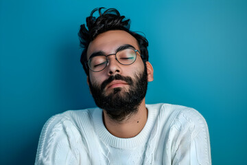 Obraz premium Captivating portrait of a young Hispanic man with beard, exuding introspection and calm against a vibrant blue backdrop. Ideal for mental health themes, lifestyle blogs, and emotional marketing.