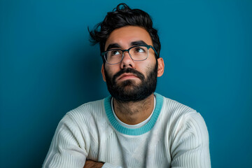 Obraz premium Professional portrait of a young man with glasses, green backdrop, embodying contemplation and creativity. Ideal for marketing, lifestyle, or educational content, featuring copy space.