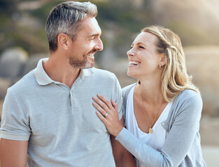 Obraz premium Laughing, happy man and woman at beach for love, trust and care or support for relationship. Together, couple and smile in nature for date or travel, marriage and joke or humour for outdoor adventure