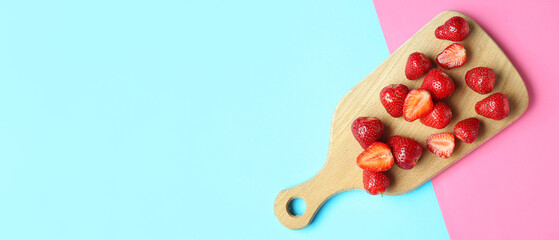 Wooden board with fresh sweet strawberries on colorful background