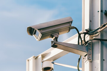 Modern Security Camera Mounted on Pole Against Clear Blue Sky for Surveillance and Safety.