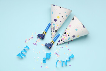 Composition with party hats, whistles and confetti on color background
