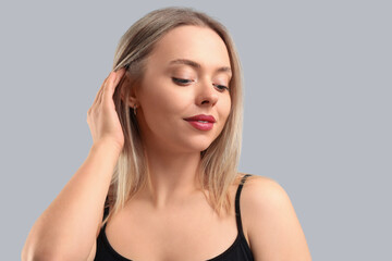 Pretty young woman on grey background. Skin care concept