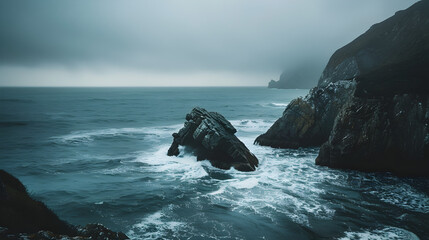 The ocean is calm and the sky is cloudy. The rocks are scattered along the shoreline