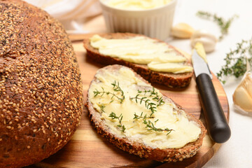 Wooden board of bread slices with fresh butter on white background