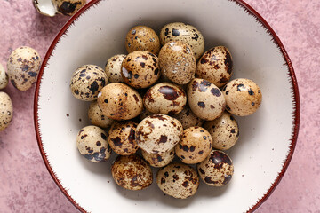 Obraz premium Bowl with quail eggs on pink grunge background