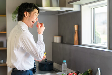 キッチンで朝食の支度をする若いアジア人ビジネスマン  © buritora