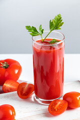 Refreshing tomato juice with parsley on white background. Vegan vegetable smoothie.