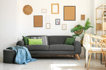 Interior of stylish living room with black sofa, houseplants and pictures