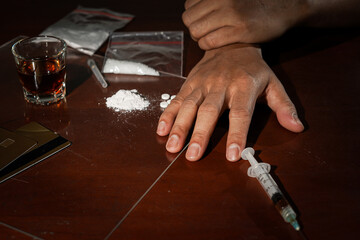 The concept of anti-drugs, Drug addict reaches for another dose of the drug in the syringe, male drug addicted