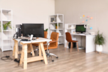 Blurred view of light office with programmer's workplaces