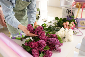 Female florist with flowers for bouquet in shop