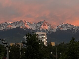 Stunning Snow-Capped Mountains at Sunset with Cityscape View