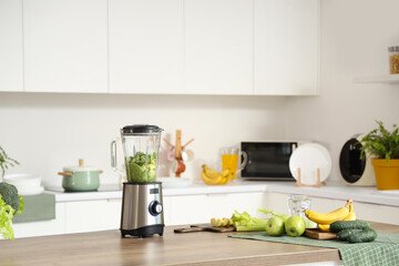 Blender with ingredients for tasty smoothie on table in kitchen