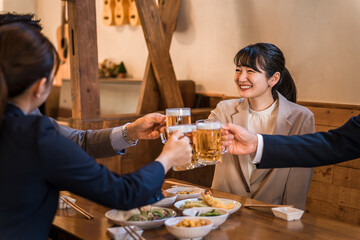 居酒屋・飲み屋で乾杯する男女のサラリーマン

