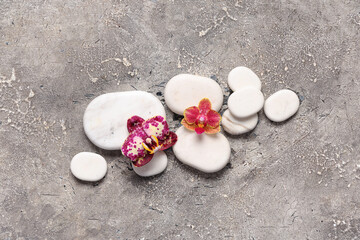 Spa stones and orchid flowers on grunge background