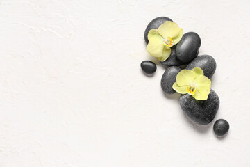 Spa stones and orchid flowers on white background
