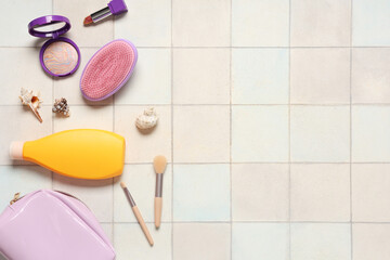 Beautiful composition with cosmetic bag, sunscreen and decorative cosmetics on tile background