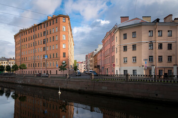 View of a residential building in the shape of an iron on the embankment of the Griboyedov Canal on a sunny day, St. Petersburg, Russia