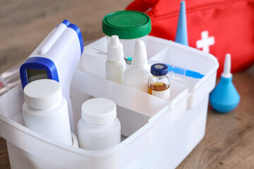 Home first aid kit with medications on table in kitchen, closeup