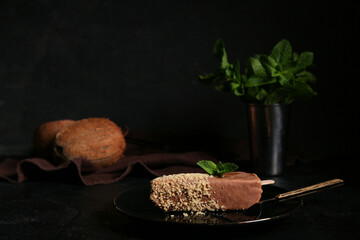 Plate with tasty cheesecake pop on black background