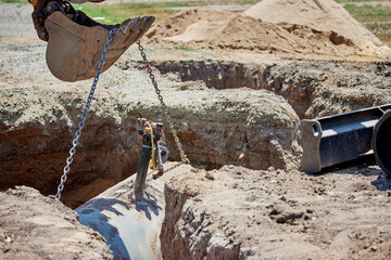 Preparing to lift out a buried propane tank with the bucket on an excavator