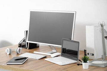 Workplace with modern computer and laptop in light office