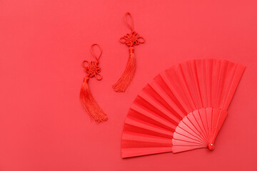 Chinese knot and hand fan on red background
