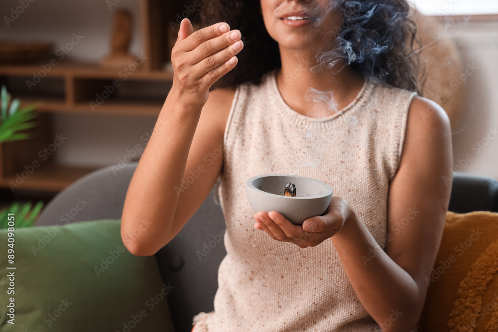 Poster Young woman with Palo Santo wood at home, closeup