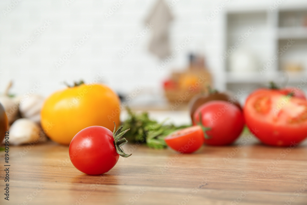 Wall mural different fresh tomatoes on wooden table in kitchen