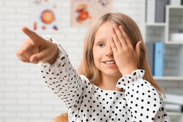 Teenage girl checking her eyesight at ophthalmologist's office, closeup. Children's Eye Health and...