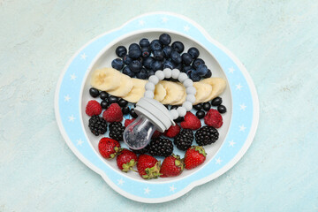 Plate with baby nibbler and fresh berries on light background