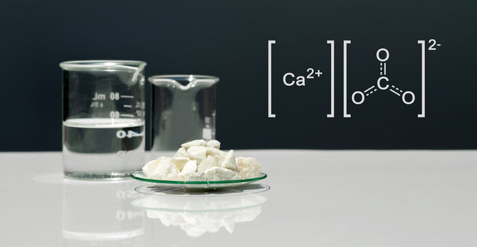 Calcium carbonate chip in chemical watch glass with molecular structure on white laboratory table. Side view