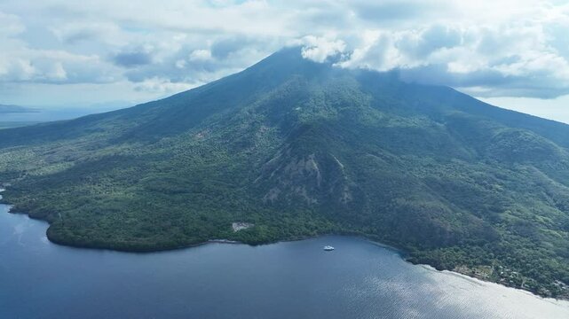 Clouds gather around the peak of the scenic volcano of Lewotolok on island of Lembata, Indonesia. This beautiful and biodiverse area is part of the famed Ring of Fire and is volcanically active.
