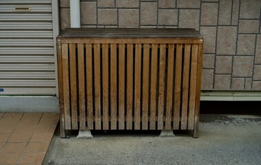 木製の柵でカバーされたエアコンの室外機