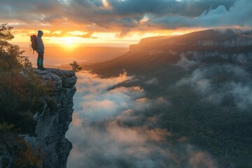 Obraz premium Hiker Admiring Sunrise Over Misty Mountain Valley