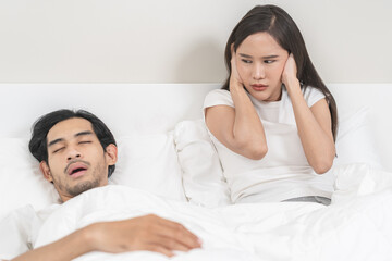 Snoring couple health asian man snore and sleeping at home while woman insomnia annoyed, bad noise...