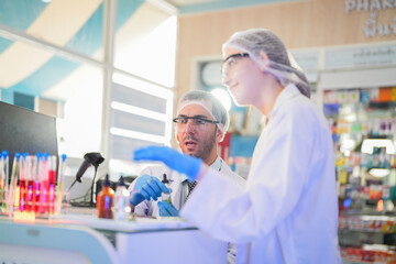 Obraz premium scientists perform experiments and record data. people arranges equipment with test tubes and chemicals for producing medicine and biochemistry. man hold tubes of chemical liquids and plant samples.
