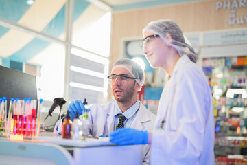 scientists perform experiments and record data. people arranges equipment with test tubes and chemicals for producing medicine and biochemistry. man hold tubes of chemical liquids and plant samples.